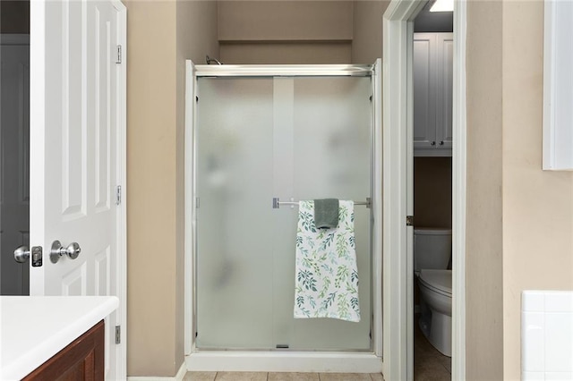 bathroom with a stall shower, toilet, and vanity