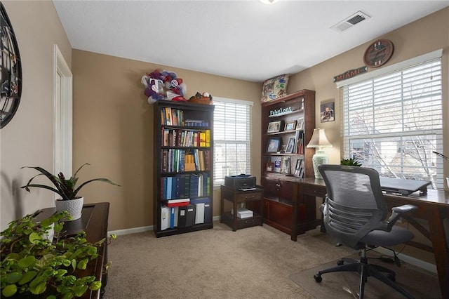 office area with visible vents, light colored carpet, and baseboards