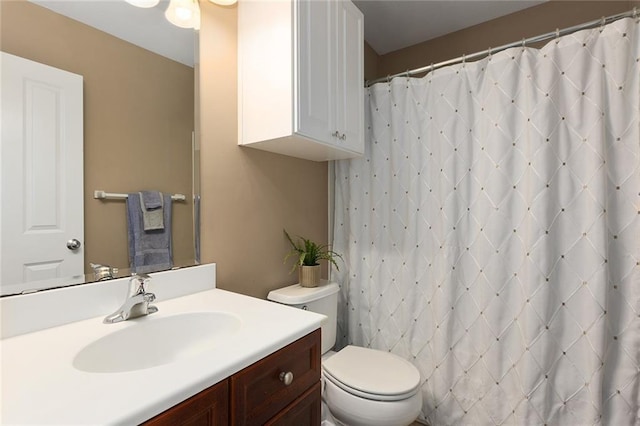 bathroom with vanity, curtained shower, and toilet