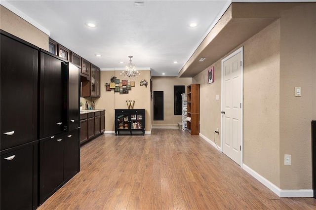 kitchen featuring glass insert cabinets, baseboards, light countertops, and light wood finished floors