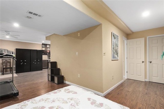 bedroom with visible vents, baseboards, and wood finished floors