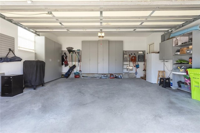 garage with a garage door opener and freestanding refrigerator