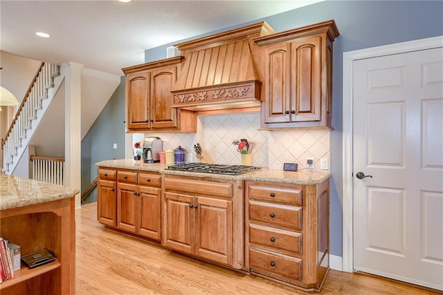 kitchen featuring open shelves, custom range hood, light wood-type flooring, and stainless steel gas cooktop