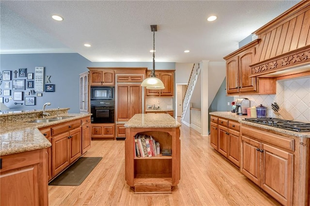 kitchen featuring black appliances, a sink, open shelves, a center island, and light wood finished floors