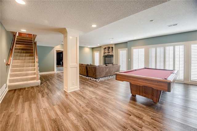 playroom featuring visible vents, a textured ceiling, a healthy amount of sunlight, and wood finished floors