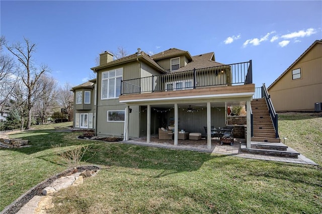 rear view of property with stairs, outdoor lounge area, a chimney, a yard, and a patio area