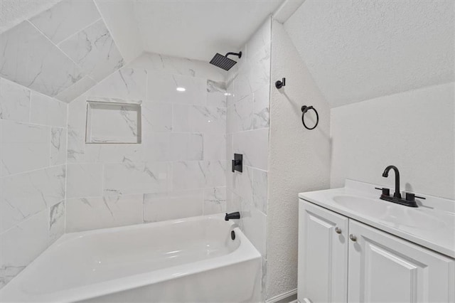 full bathroom with lofted ceiling, vanity, shower / bathtub combination, and a textured wall