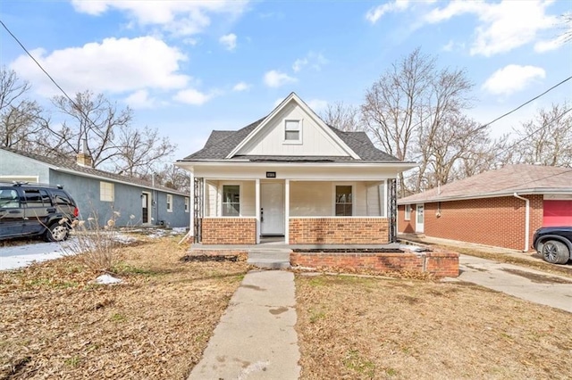 bungalow-style home featuring board and batten siding, brick siding, and covered porch