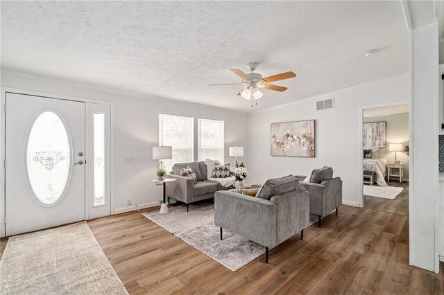 1310 Lawrence Ave, Kansas City, KS 66103 - living area with ceiling fan, visible vents, a textured ceiling, and wood finished floors