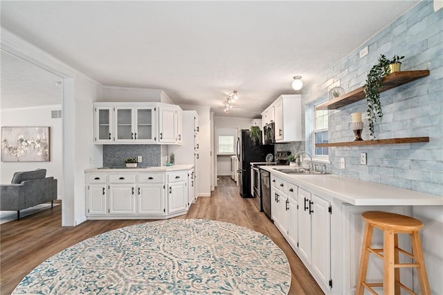 1310 Lawrence Ave, Kansas City, KS 66103 - kitchen with light wood finished floors, white cabinets, light countertops, and open shelves