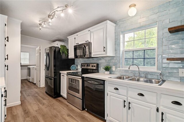1310 Lawrence Ave, Kansas City, KS 66103 - kitchen featuring decorative backsplash, a healthy amount of sunlight, black appliances, and a sink
