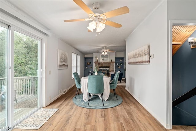 1310 Lawrence Ave, Kansas City, KS 66103 - dining room with visible vents, a fireplace, light wood-style floors, and baseboards