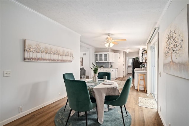 1310 Lawrence Ave, Kansas City, KS 66103 - dining space featuring a ceiling fan, wood finished floors, baseboards, and a textured ceiling