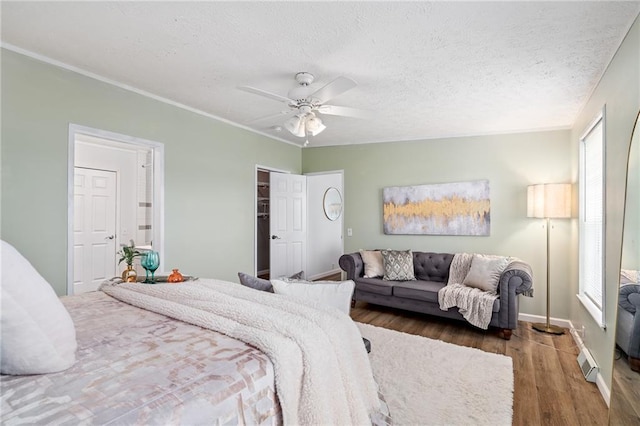 1310 Lawrence Ave, Kansas City, KS 66103 - bedroom featuring visible vents, a textured ceiling, wood finished floors, crown molding, and ceiling fan