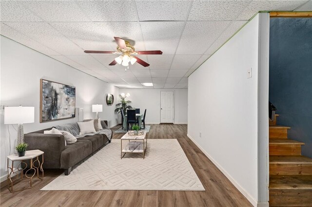 1310 Lawrence Ave, Kansas City, KS 66103 - living area with a ceiling fan, stairway, wood finished floors, and a paneled ceiling