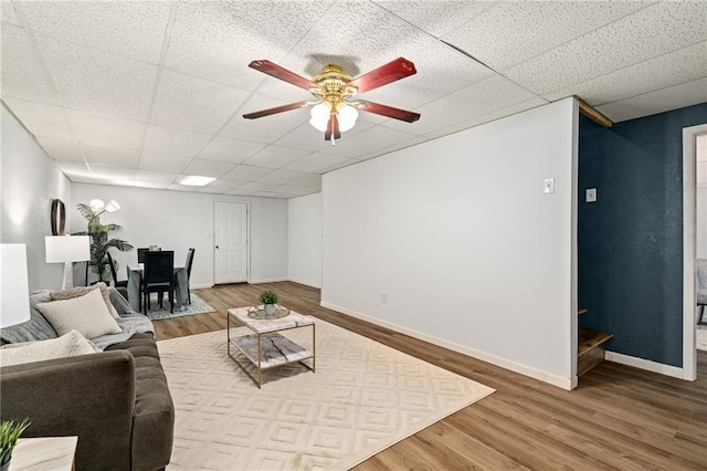 1310 Lawrence Ave, Kansas City, KS 66103 - living area featuring ceiling fan, wood finished floors, baseboards, and a paneled ceiling