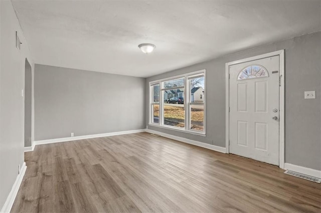 entrance foyer featuring baseboards, visible vents, and wood finished floors