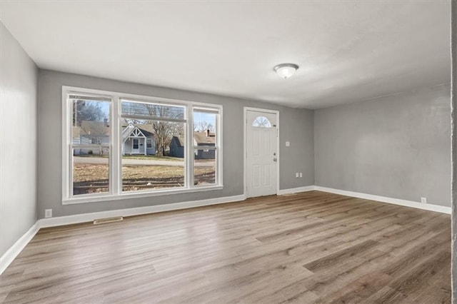 foyer with visible vents, baseboards, and wood finished floors