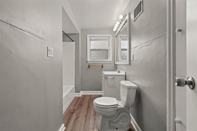 bathroom featuring visible vents, toilet, vanity, wood finished floors, and baseboards