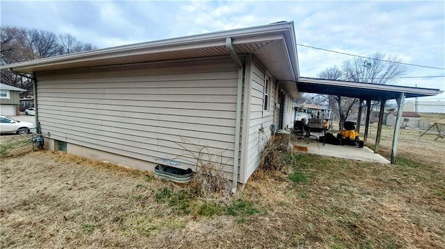 view of side of property with a patio, a carport, and driveway