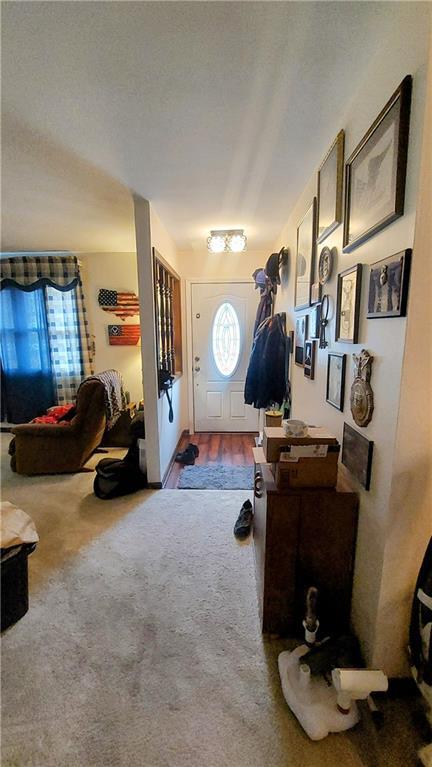 foyer with a textured ceiling and carpet floors