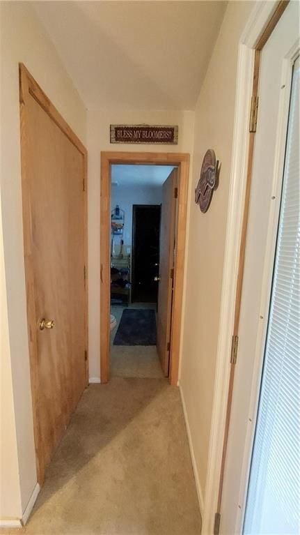 hallway with light carpet and baseboards