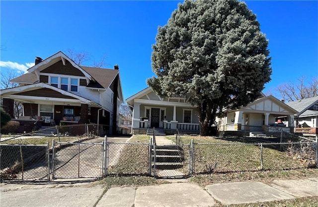 bungalow-style house featuring a porch, a fenced front yard, and a gate