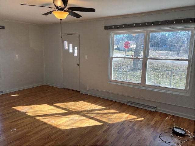 entryway featuring ceiling fan, visible vents, baseboards, and wood finished floors