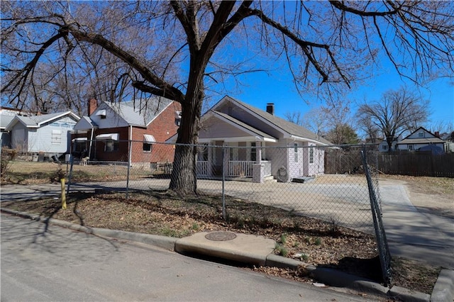 bungalow-style house with a fenced front yard, a residential view, and a chimney