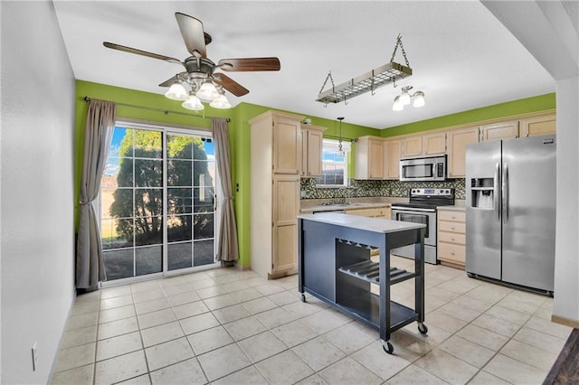 kitchen with tasteful backsplash, light brown cabinets, light countertops, appliances with stainless steel finishes, and a sink