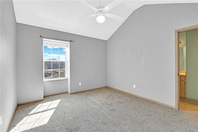 unfurnished bedroom featuring lofted ceiling, ensuite bathroom, baseboards, and carpet floors