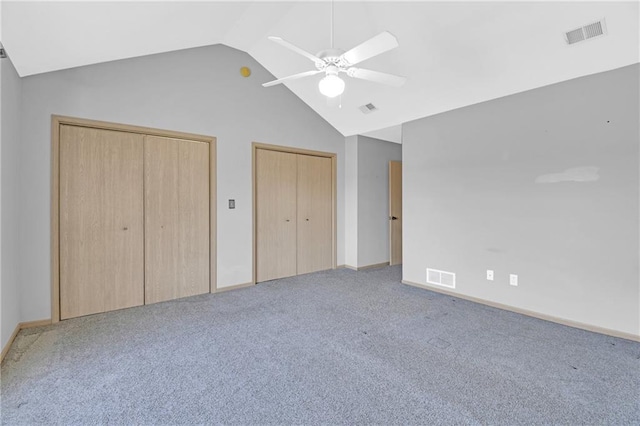 unfurnished bedroom featuring visible vents, multiple closets, and vaulted ceiling