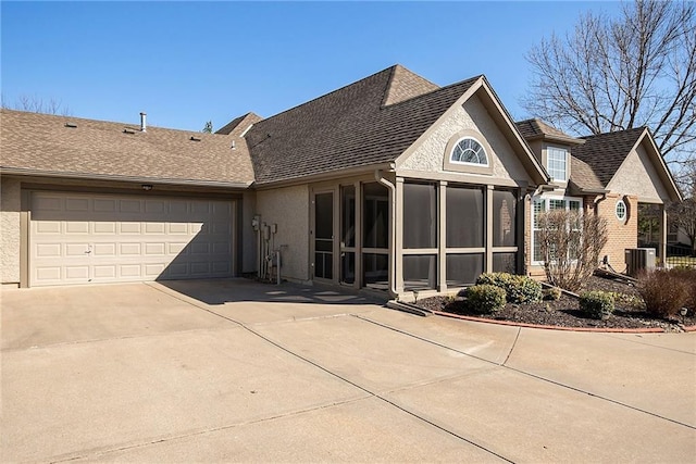 view of front of property with concrete driveway, a garage, a sunroom, and stucco siding