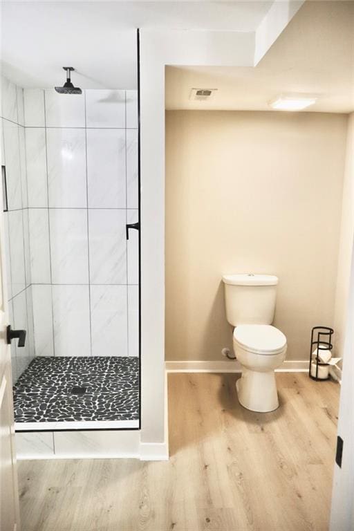 bathroom featuring visible vents, a shower stall, baseboards, toilet, and wood finished floors