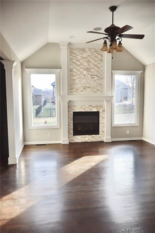 unfurnished living room with lofted ceiling, wood finished floors, a fireplace, baseboards, and ceiling fan