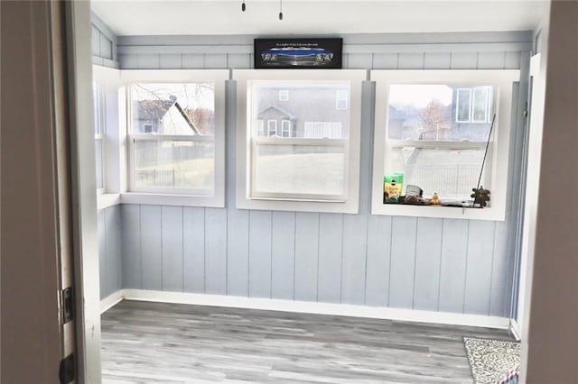 interior space featuring plenty of natural light, baseboards, and wood finished floors