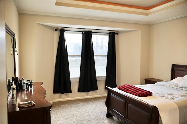 carpeted bedroom with baseboards, a raised ceiling, and ornamental molding