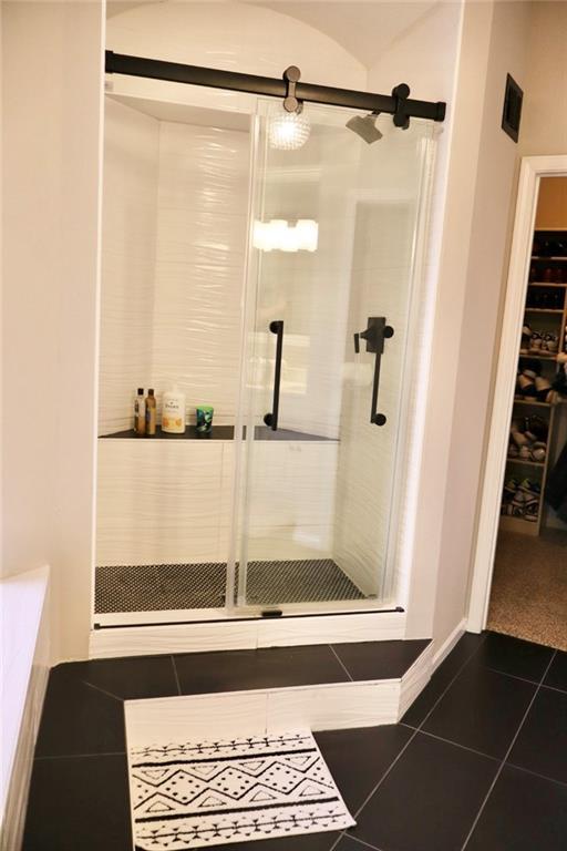 bathroom featuring tile patterned floors and a shower stall