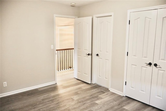 unfurnished bedroom featuring baseboards and wood finished floors