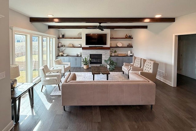 living area with dark wood-style floors, beamed ceiling, a glass covered fireplace, and baseboards