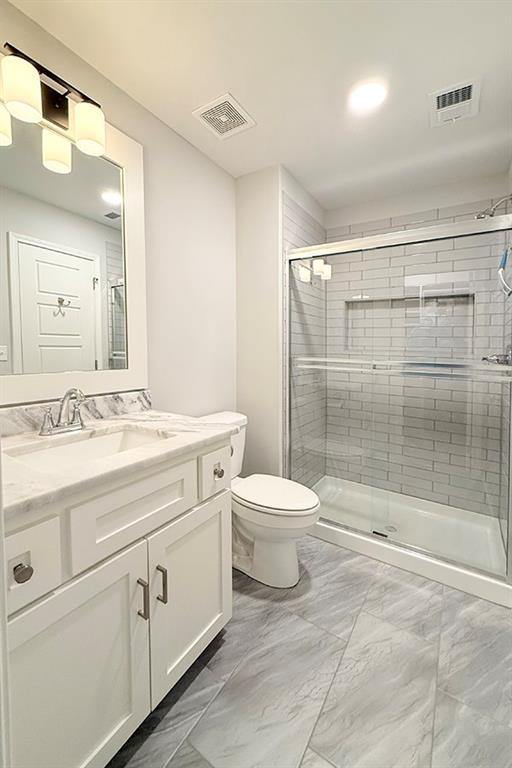 full bath featuring marble finish floor, visible vents, and a shower stall