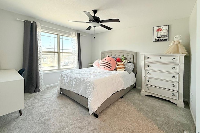 bedroom with ceiling fan, baseboards, and light colored carpet