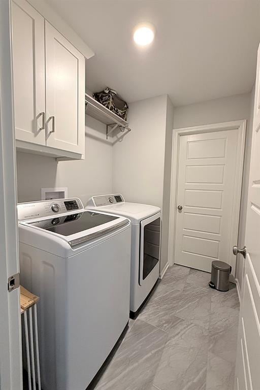 washroom featuring marble finish floor, cabinet space, and independent washer and dryer