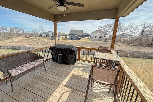 wooden deck featuring a yard, area for grilling, ceiling fan, fence, and a residential view