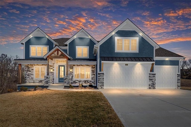 view of front of property with a front lawn, driveway, a standing seam roof, stone siding, and metal roof