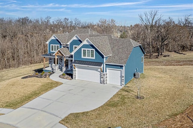 view of front of house featuring driveway, a standing seam roof, a front yard, a shingled roof, and metal roof