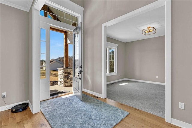 foyer featuring visible vents, baseboards, and wood finished floors