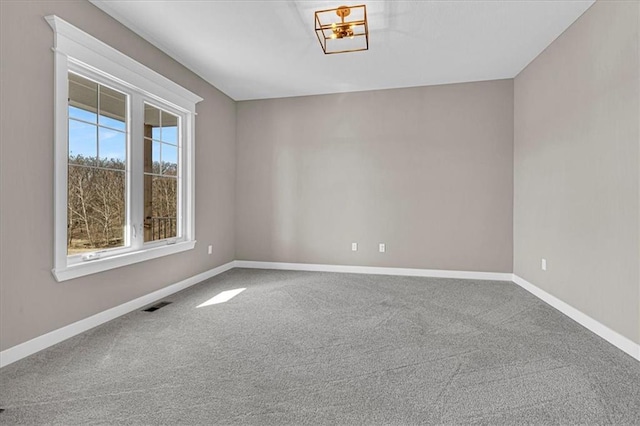 carpeted spare room featuring visible vents and baseboards