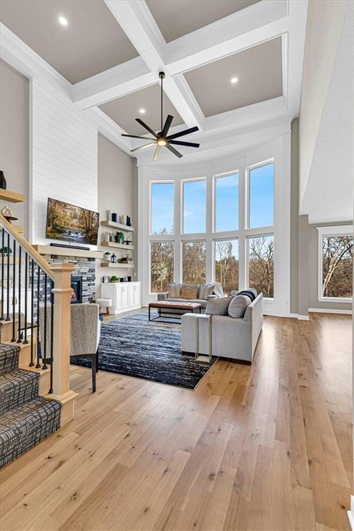 living room with stairway, coffered ceiling, a fireplace, ceiling fan, and hardwood / wood-style flooring