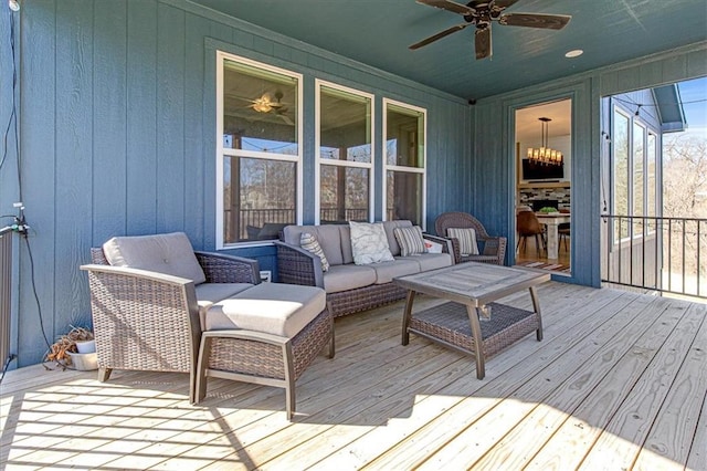 wooden deck with an outdoor living space and a ceiling fan